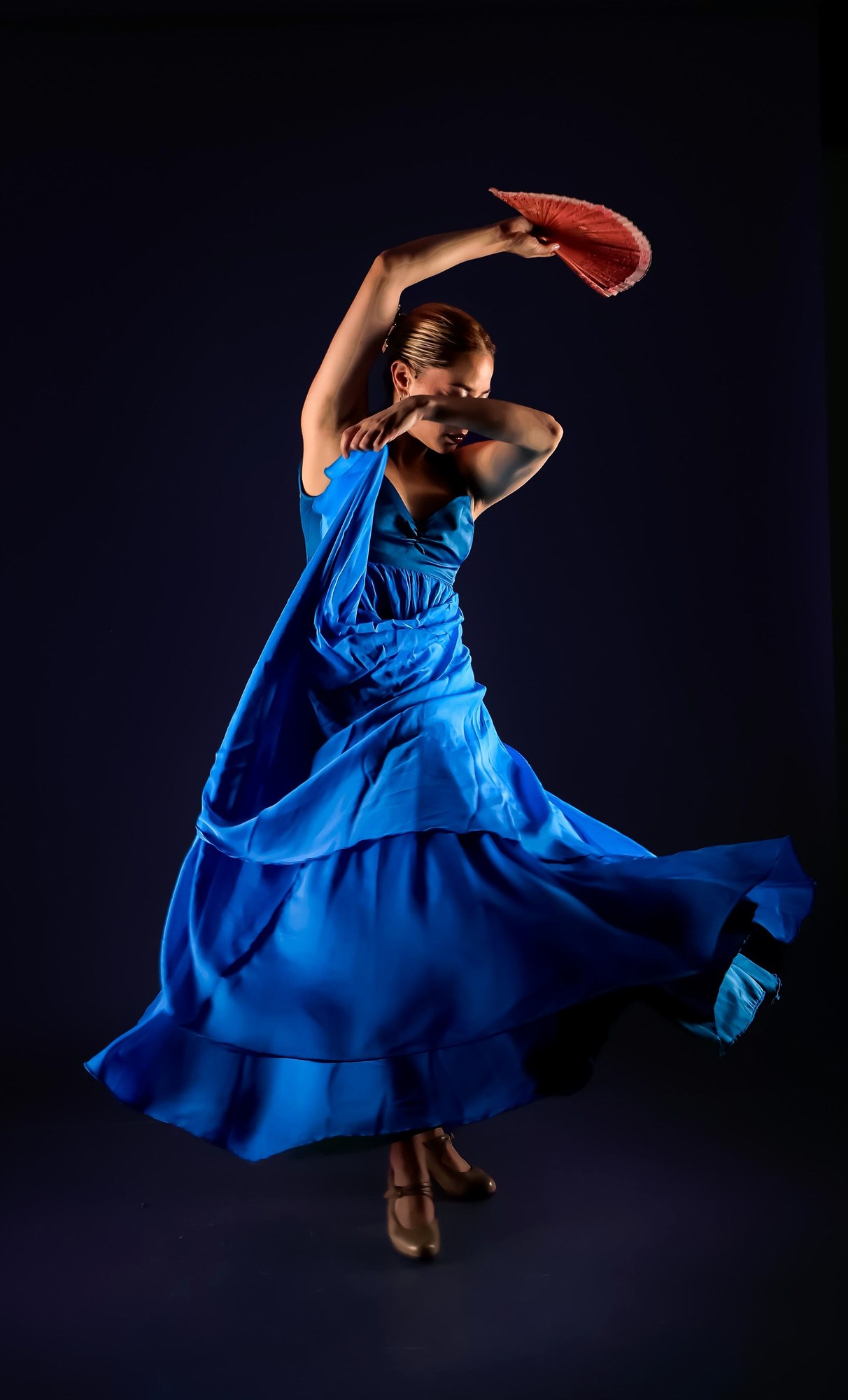 Escena de flamenco en sala pequeña, movimiento, luz dramática, sin tópicos.