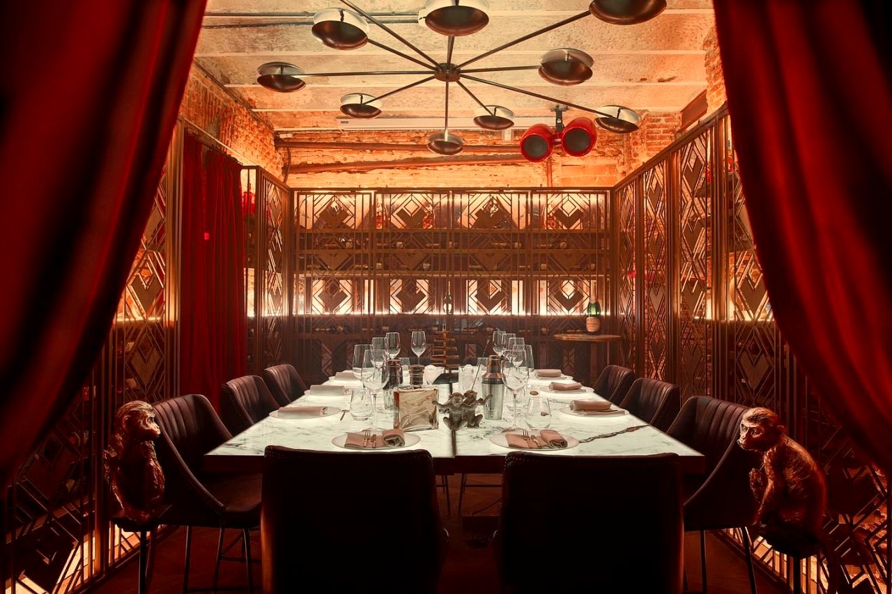 Sala de restaurante reservada, mesa larga, ambiente sobrio.