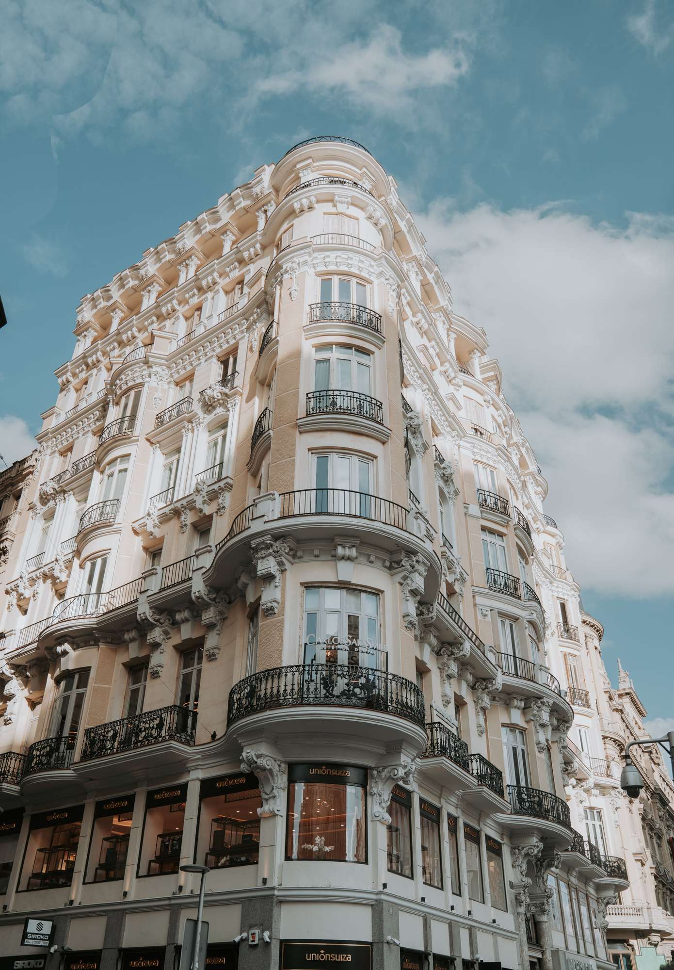 Calle residencial madrileña al amanecer, balcones, luz limpia.
